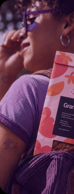 Woman in purple glasses carrying a Fruitvent granola pack in her backpack