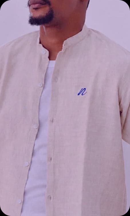 Man in a linen shirt with an embroidered blue n